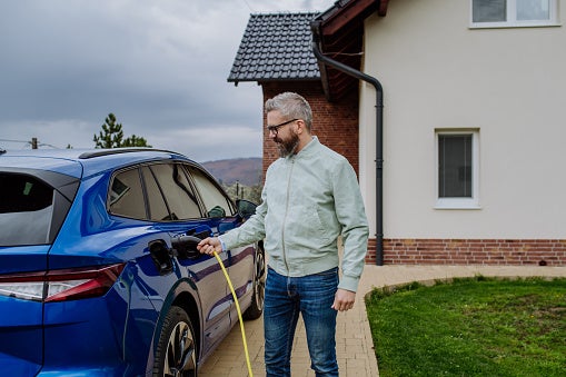 Man charging EV at home